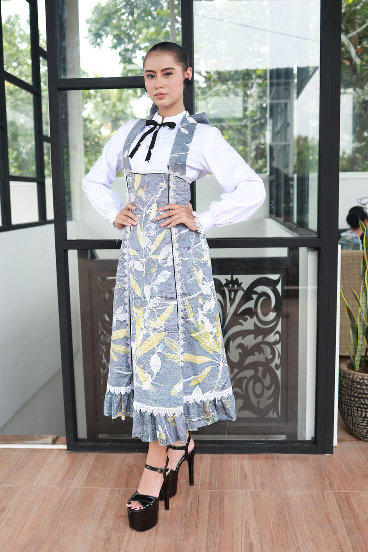 Blue eco-print pinafore worn over wide-leg trousers